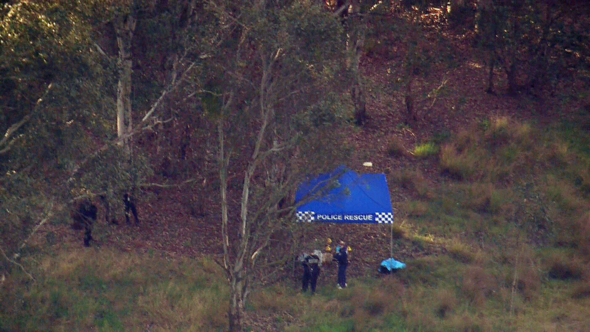 An aerial photo of the police under a canopy after a body was found 