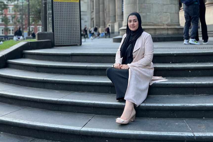 Ms Afrasiabi sits on the stairs outside the State Library of Victoria