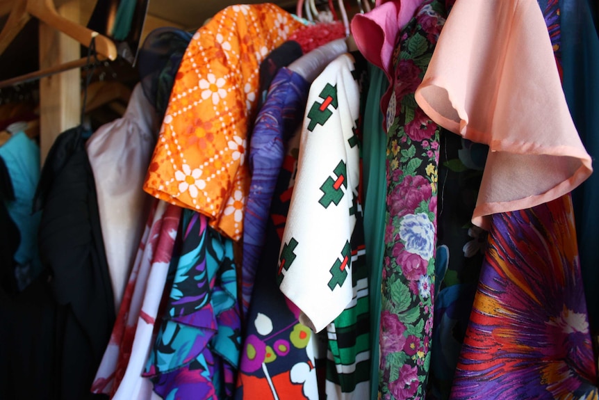 Colourful clothes hanging on a rack.