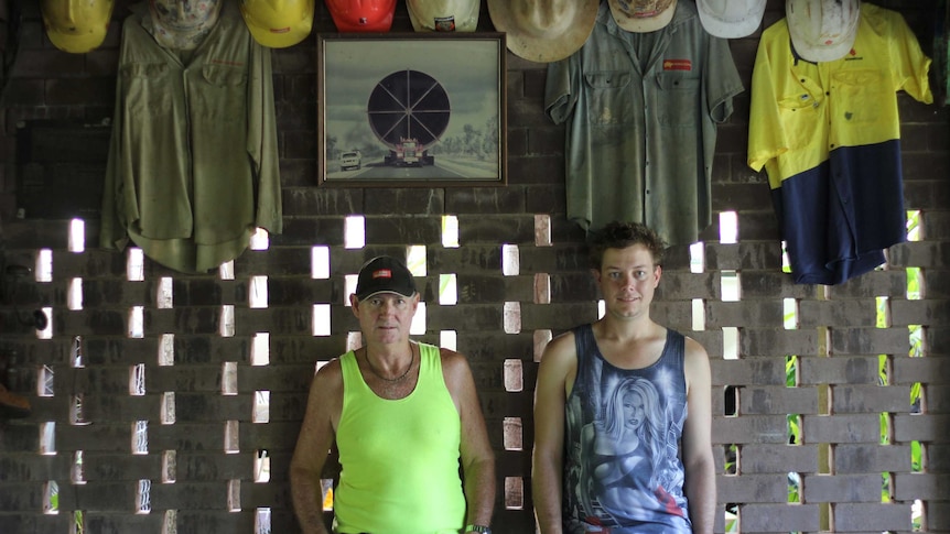 two men under a row of hard hats