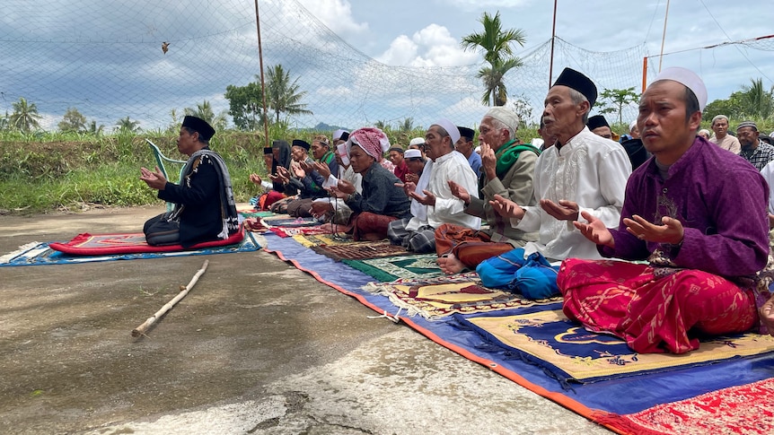 Muslim men attend Friday prayers at a volleyball court.