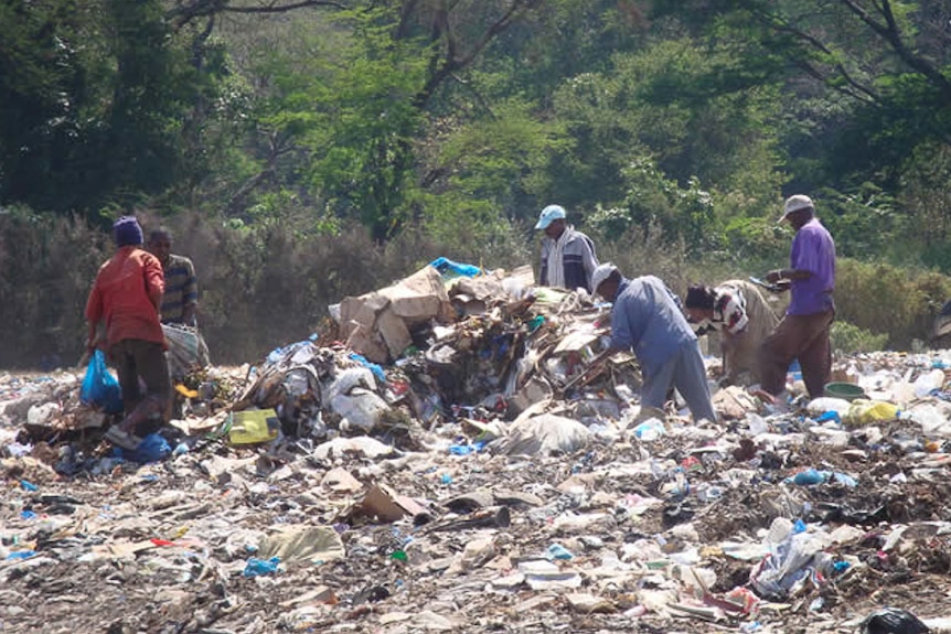 Moshi residents search through rubbish piles.