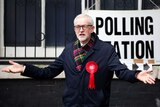 Jeremy Corbyn with his arms outstretched outside a polling station