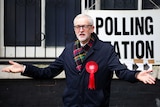 Jeremy Corbyn with his arms outstretched outside a polling station