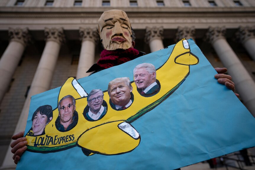 A protestor stands alone outside a courthouse with an image of a plane and the faces of Epstein, Maxwell and others.