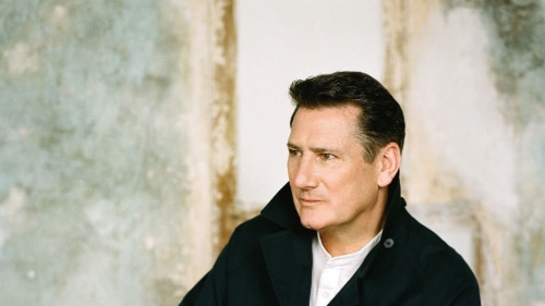 Photo of Tony Hadley wearing a black jacket with a white t-shirt 