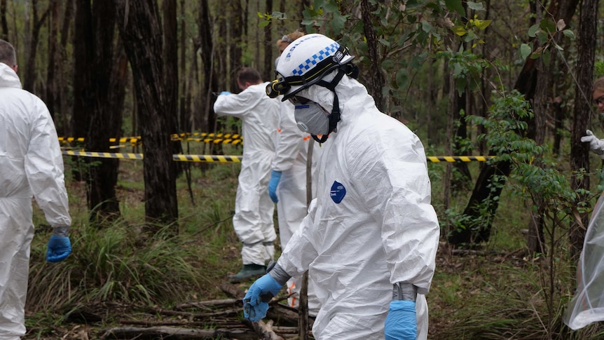A forensic police officer walks through bushland at the AFTER facility near Sydney, February 2020.