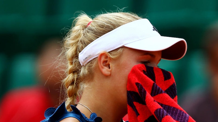 Caroline Wozniacki wipes her face in a shock third-round defeat.