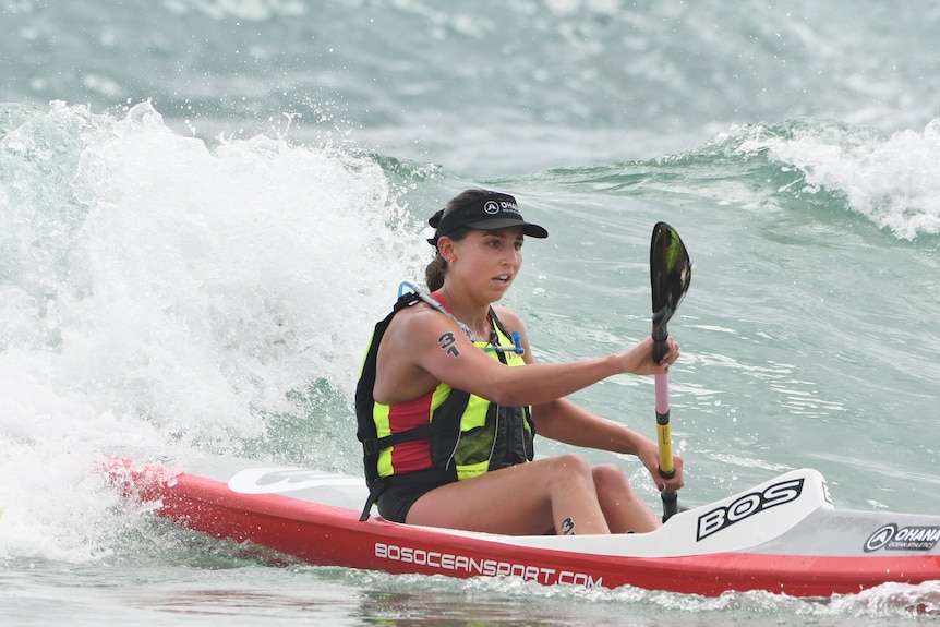 Ironwoman Carla Papac sits and paddles in the water during a race