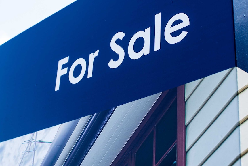 Close up of a sign advertising a house for sale in Brisbane.