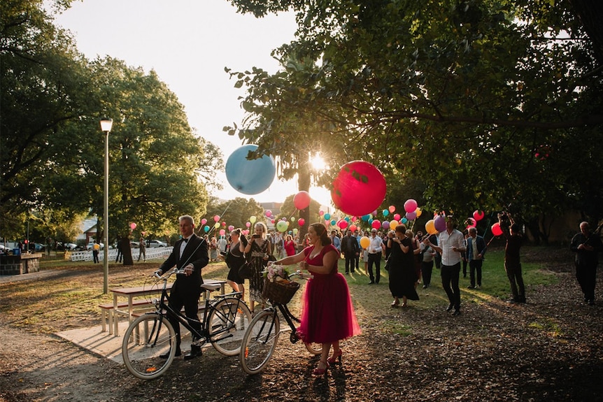 Guests walk from the Love Party ceremony to dinner carrying balloons.