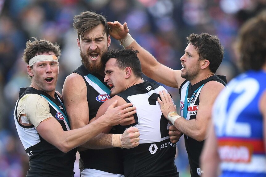 Charlie Dixon of the Power (2L) reacts after kicking a goal against Western Bulldogs in Ballarat.