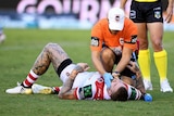 Josh Dugan receives medical attention on the field.