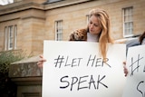 Young woman holding a sign saying #LetHerSpeak