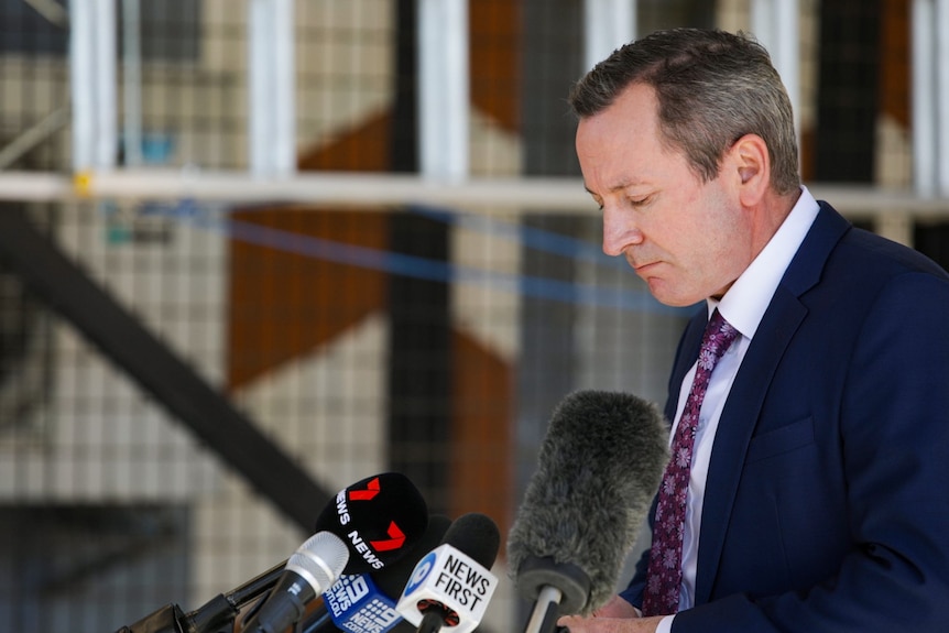 Mark McGowan looks down at his hands as he addresses media