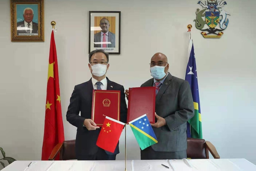 中国驻所罗门群岛大使李明(左)和所罗门群岛外交官科林·贝克同意两国之间的安全条约。