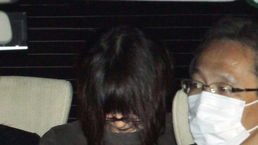 Aum cult member Naoko Kikuchi in the back of a police car.