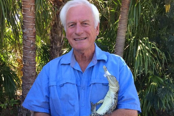 A young crocodile in the arms of a crocodile farmer.