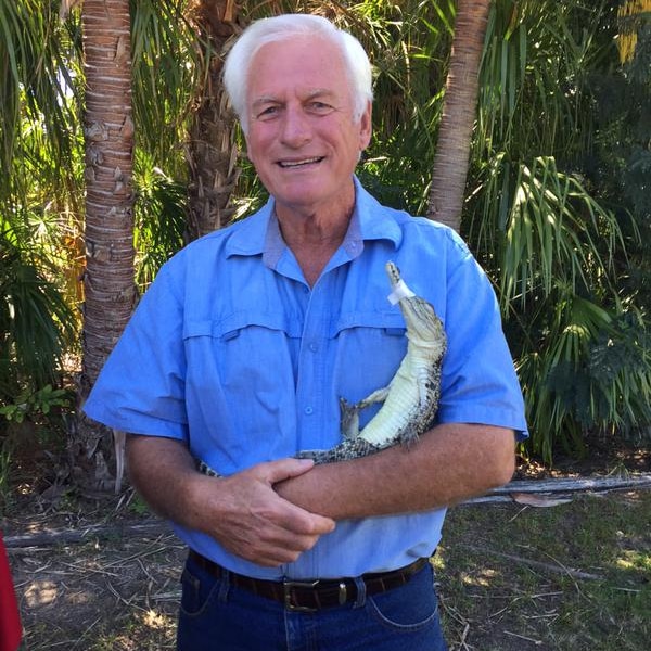 A young crocodile in the arms of a crocodile farmer.