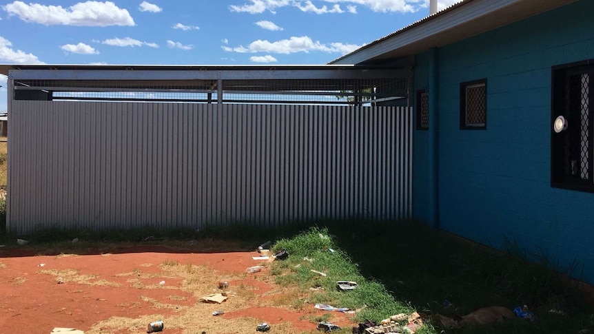 Rubbish is littered on the ground next to a house in Ali Curung.