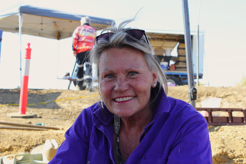 Woman in a purple shirt smiling at the camera