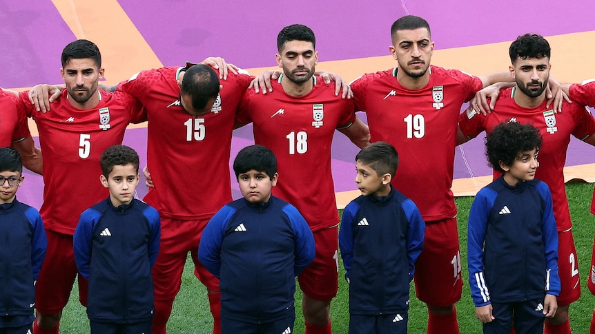The Iran football team stand along side each other at the opening ceremony of the world cup.