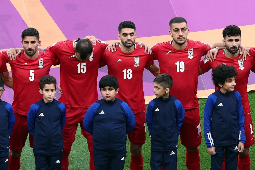 The Iran football team stand along side each other at the opening ceremony of the world cup.