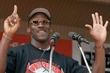 Michael Jordan holds up six fingers while standing at the podium at the Chicago Bulls' championship parade.
