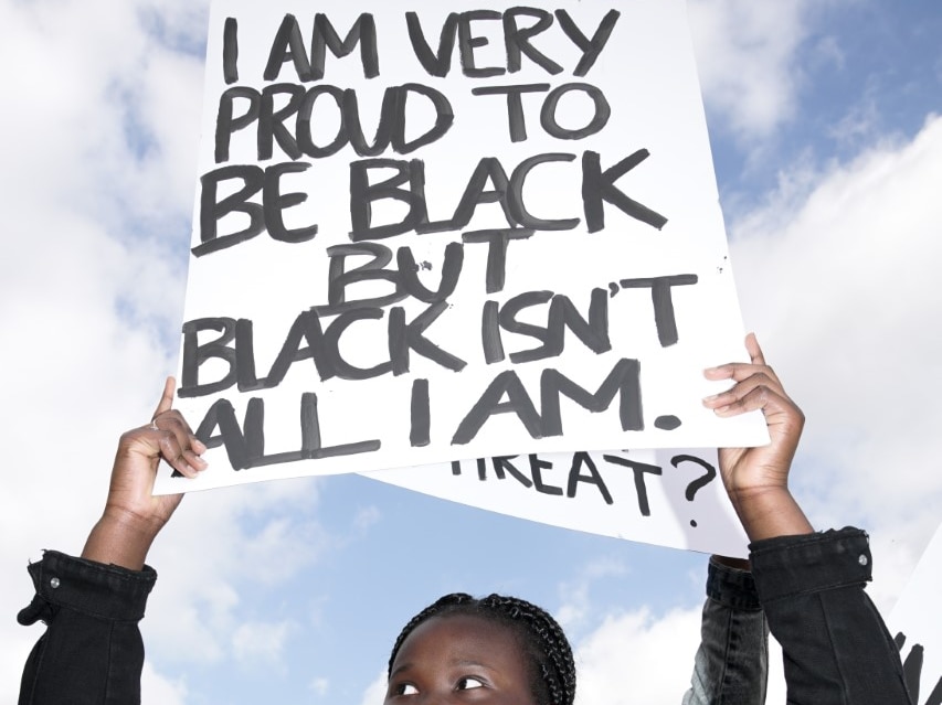 A black protester holds up a sign during the Adelaide Black Lives Matter protest