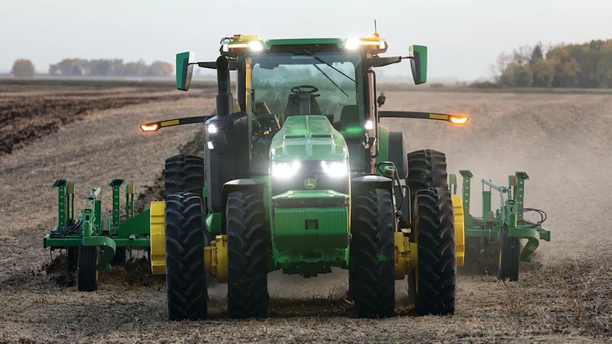 Tractor with no driver has lights on in field