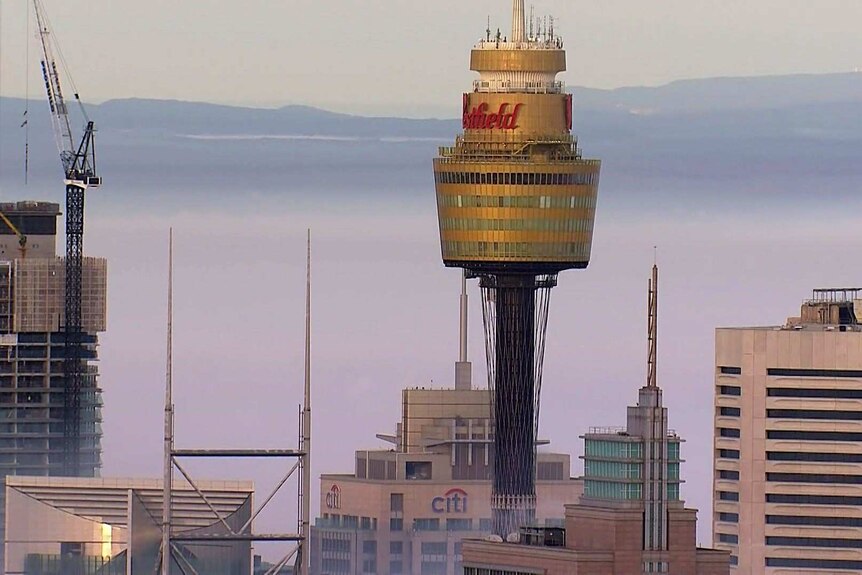 The top of Sydney's Westfield Tower surrounded by fog.