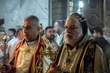 Priests hold candles as they lead midnight mass at the Assyrian Orthodox Church in Bartella, Iraq.