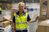 Samantha Campbell smiling while standing in a largely empty warehouse.