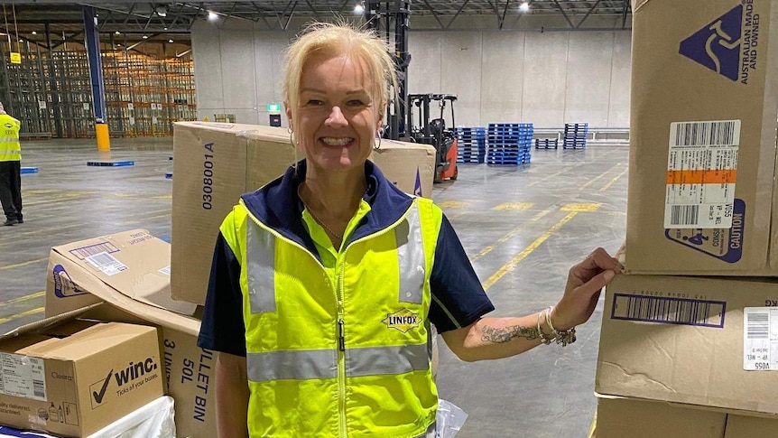 Samantha Campbell smiling while standing in a largely empty warehouse.