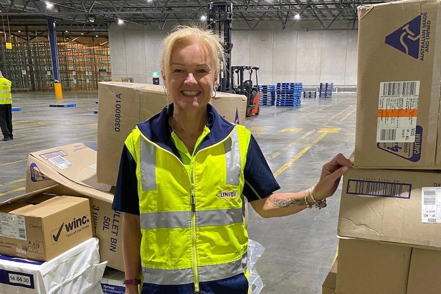 Samantha Campbell smiling while standing in a largely empty warehouse.