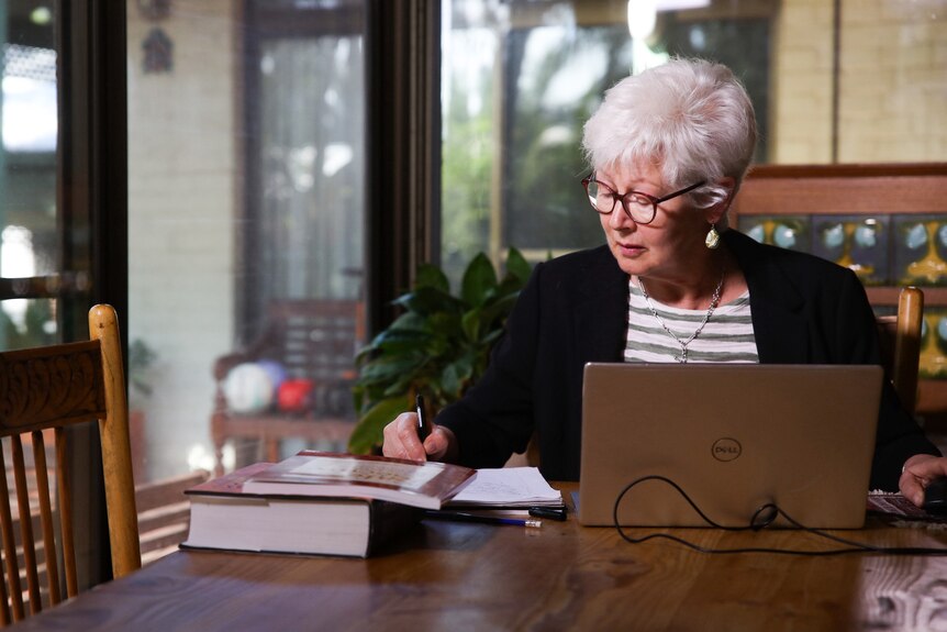 Dr Gothard working at a desk in her home.