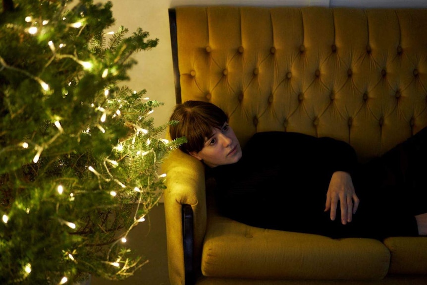 A scene from tv series Normal People with the character Marianna lying on a couch looking sad