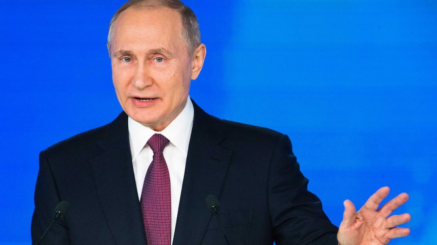 Russian President Vladimir Putin gestures with his right hand.