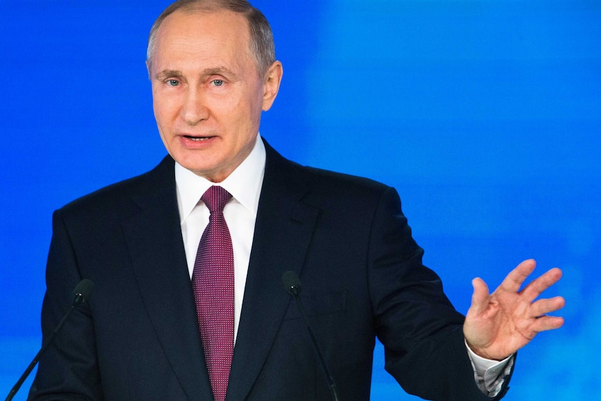 Russian President Vladimir Putin gestures with his right hand.