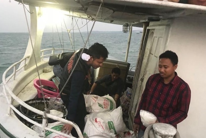 Indonesian police inspect ice in sacks aboard the Sunrise Glory.
