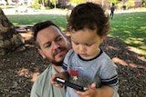Michael Fogarty with his son Ethan, who is using an iPhone.
