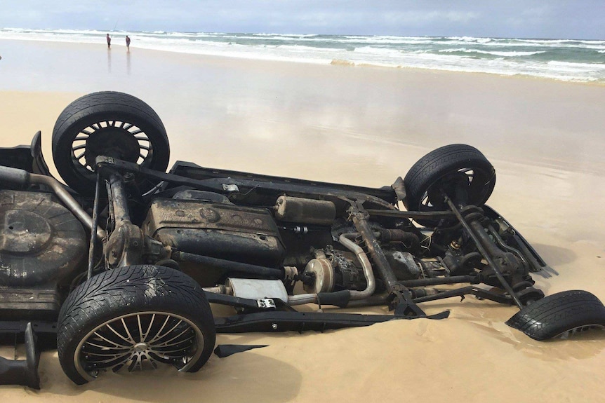 Man looking at range rover buried in sand