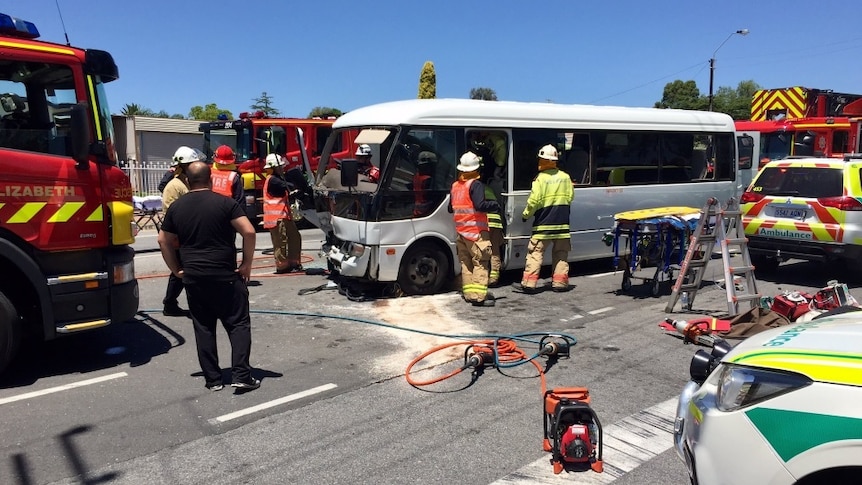 Emergency crews at the scene of a collision between a bus and truck.