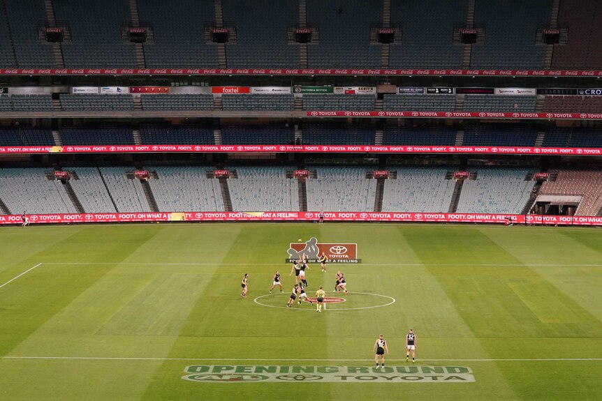An AFL match is played at the MCG with no spectators in the stadium.