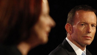 Tony Abbott looks at Gillard during the debate (AAP)