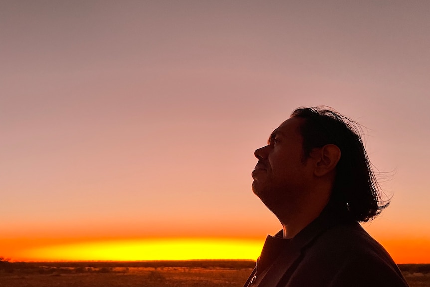Man's silhouette with sunset in background