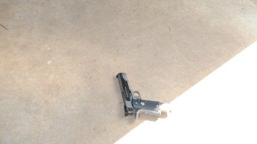 A handgun lying on the ground of a shed