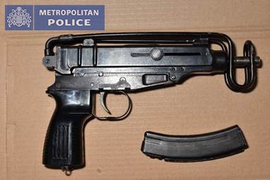 A sub machine gun with clip of ammunition.