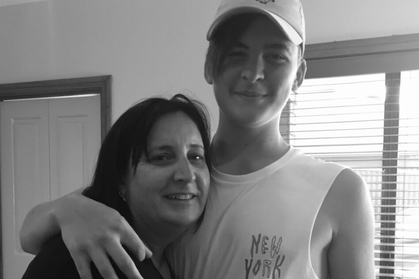 A black and white photo of a mother and son smiling.