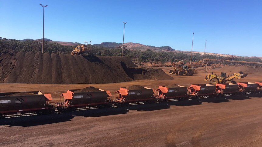 Rolling stock with iron ore being loaded in regional Western Australia